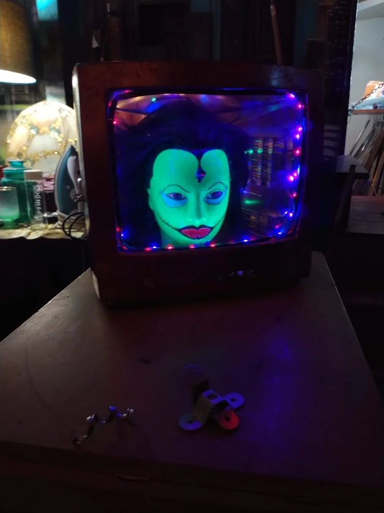A glowing green face inside a vintage television set